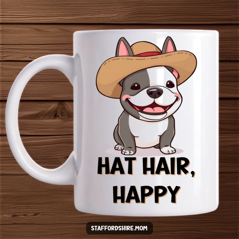 Funny Staffordshire bull terrier mug showing a dog wearing a silly, oversized hat and giggling with delight.