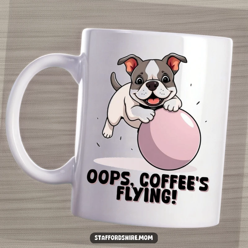 Funny Staffordshire Bull Terrier mug showing a dog playfully tripping over a comically large ball, capturing a moment of adorable mishap.