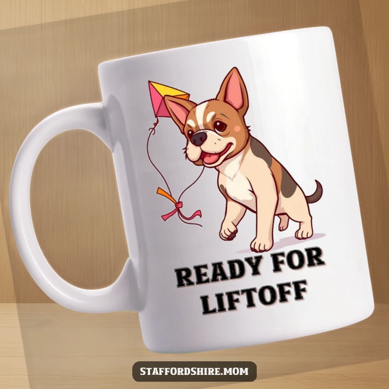 Funny determined Staffordshire dog mug, carrying a large colorful kite, symbolizing ambition and fun.