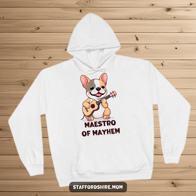 Funny Staffordshire Bull Terrier hoodie showing a dog enthusiastically playing a tiny instrument, perfect for cozy music sessions.