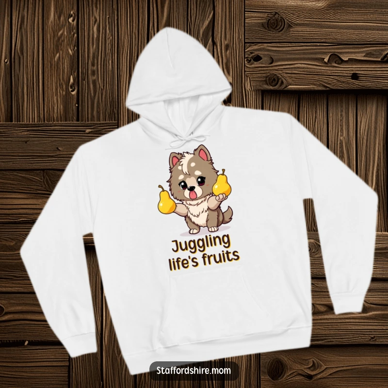 Funny Staffy hoodie depicting a determined dog juggling glowing pears, emphasizing focus and impressive skill.