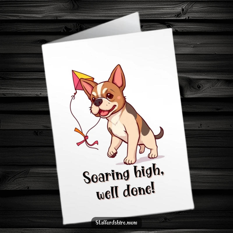 Free Printable Congratulations Card showing a determined Staffordshire dog carrying a large, colorful kite, symbolizing success.