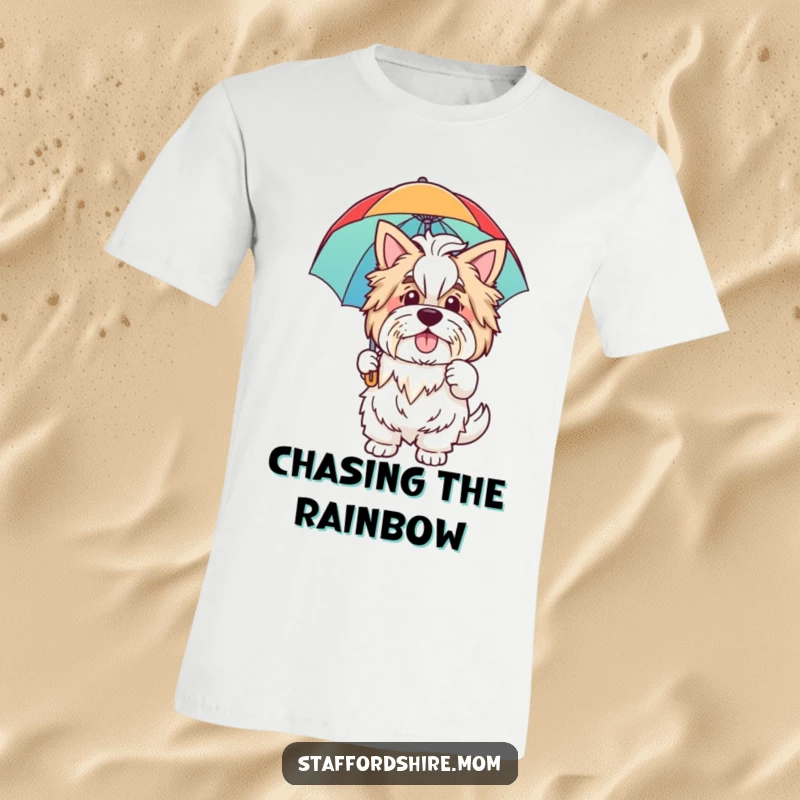 Funny t-shirt with a friendly Staffordshire dog waving warmly, holding a bright rainbow umbrella, symbolizing joy and good times.